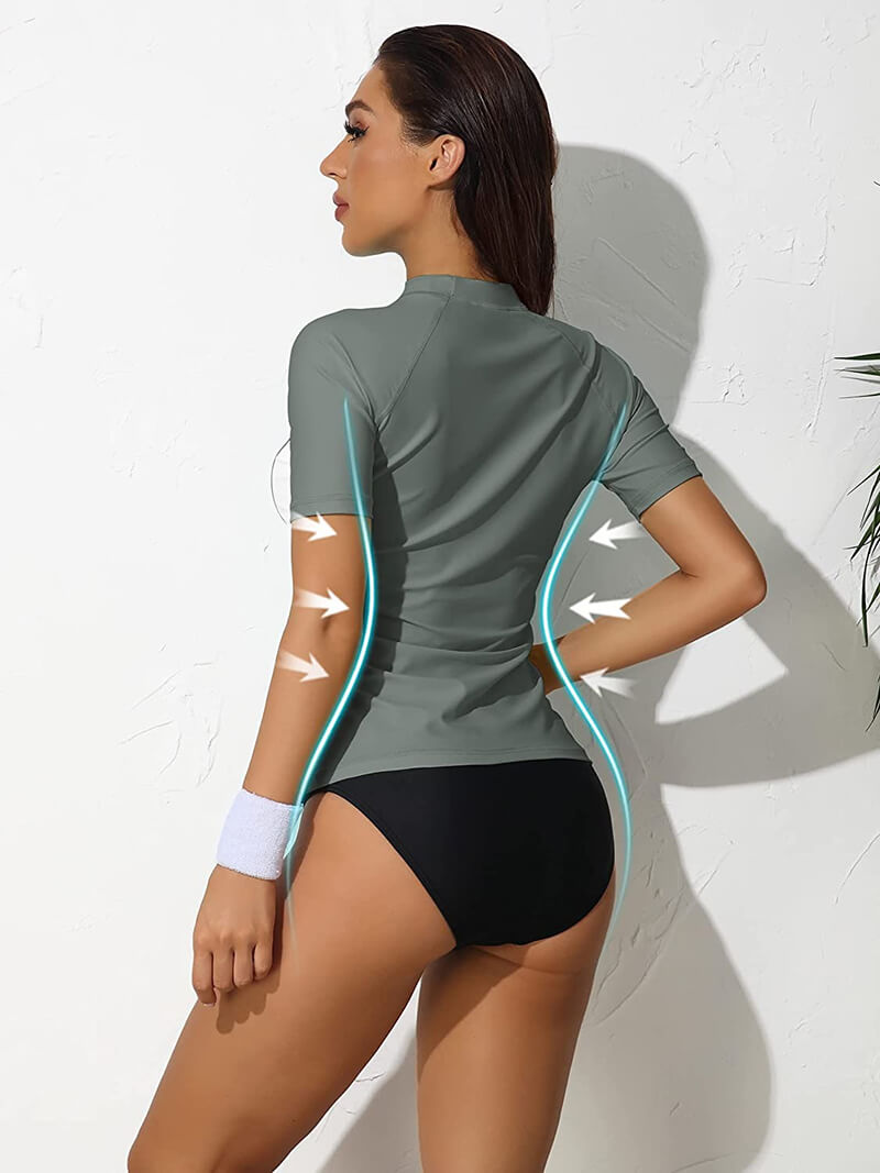 Woman wearing women's surfing crew neck rashguard swimwear with short sleeves in gray, showing elastic fit and UV protection, back view.